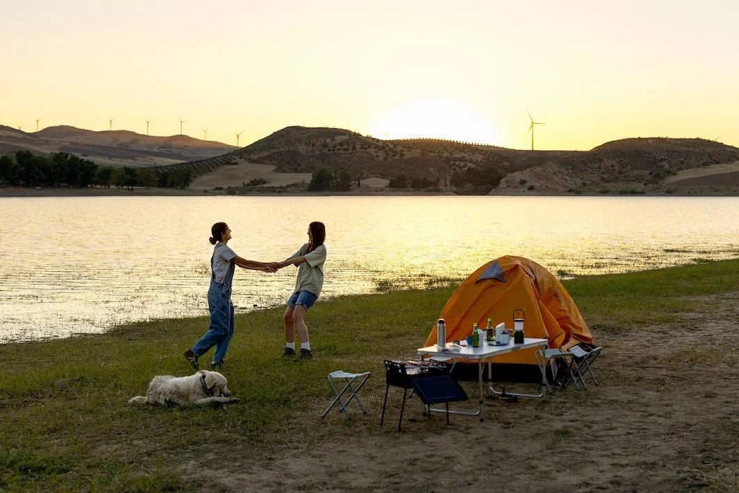 Travelers enjoying a coastal camping trip in Khasab with tents near the beach and scenic mountain views