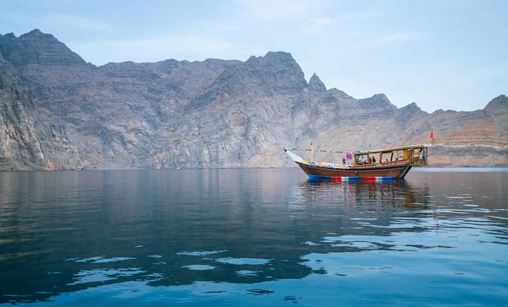 Traditional dhow cruise sailing through the stunning fjords of Musandam during a holiday package tour